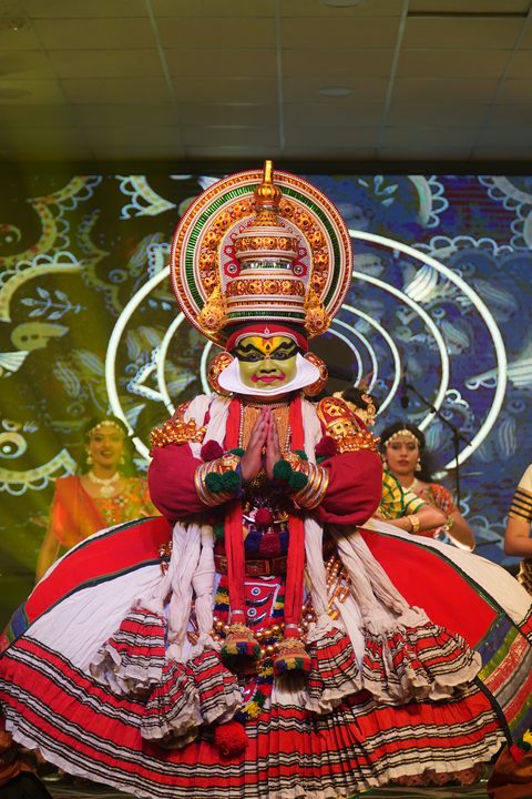 Kathakali performer in ornate headdress with classical dancers on the culturals stage